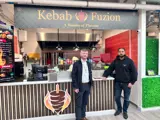 Two men standing in front of a food stall