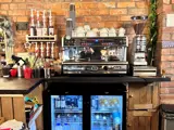 An image of a barista coffee machine on a counter top with a drinks fridge below