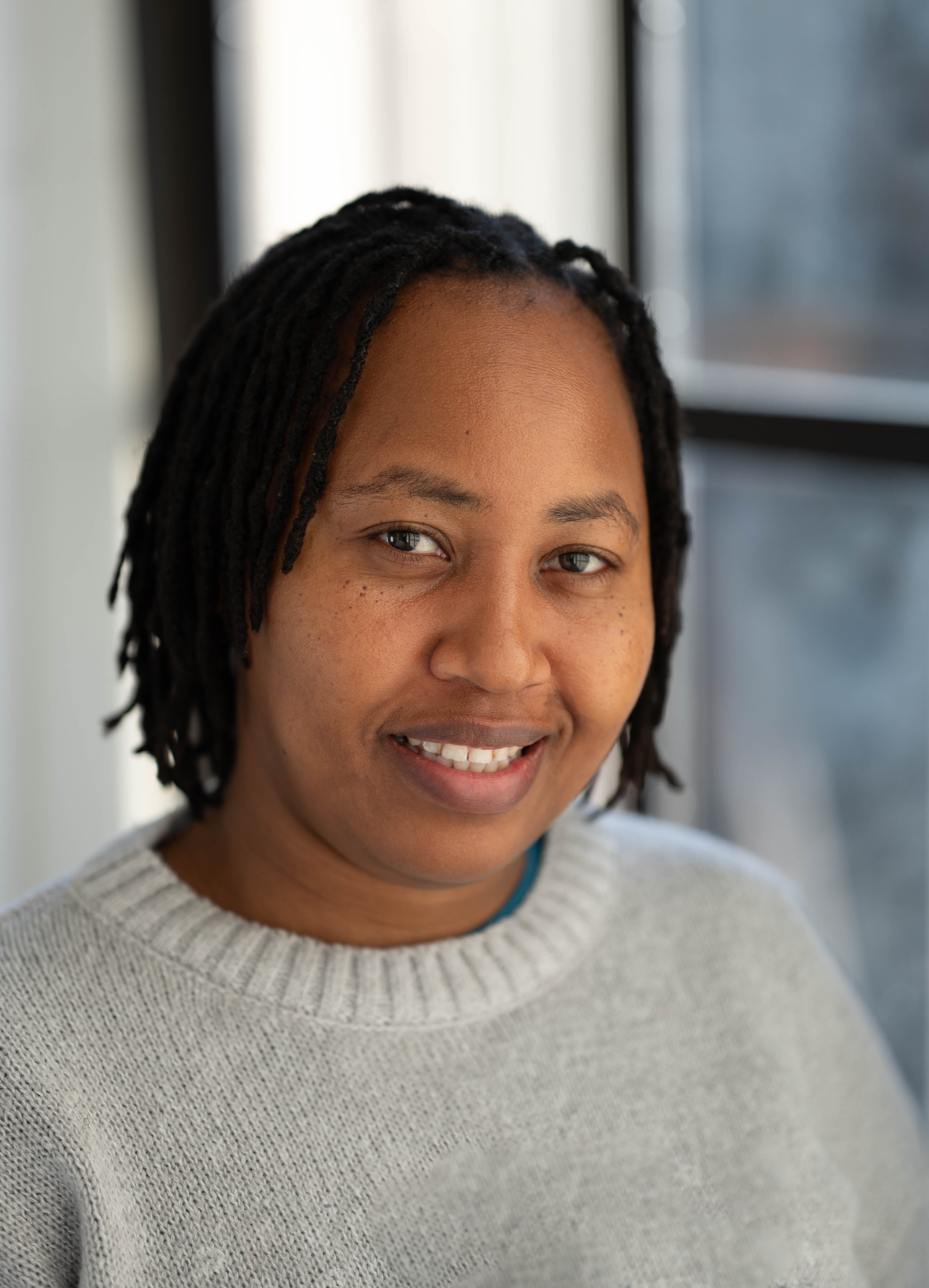 A lady posing for a headshot and smiling at the camera