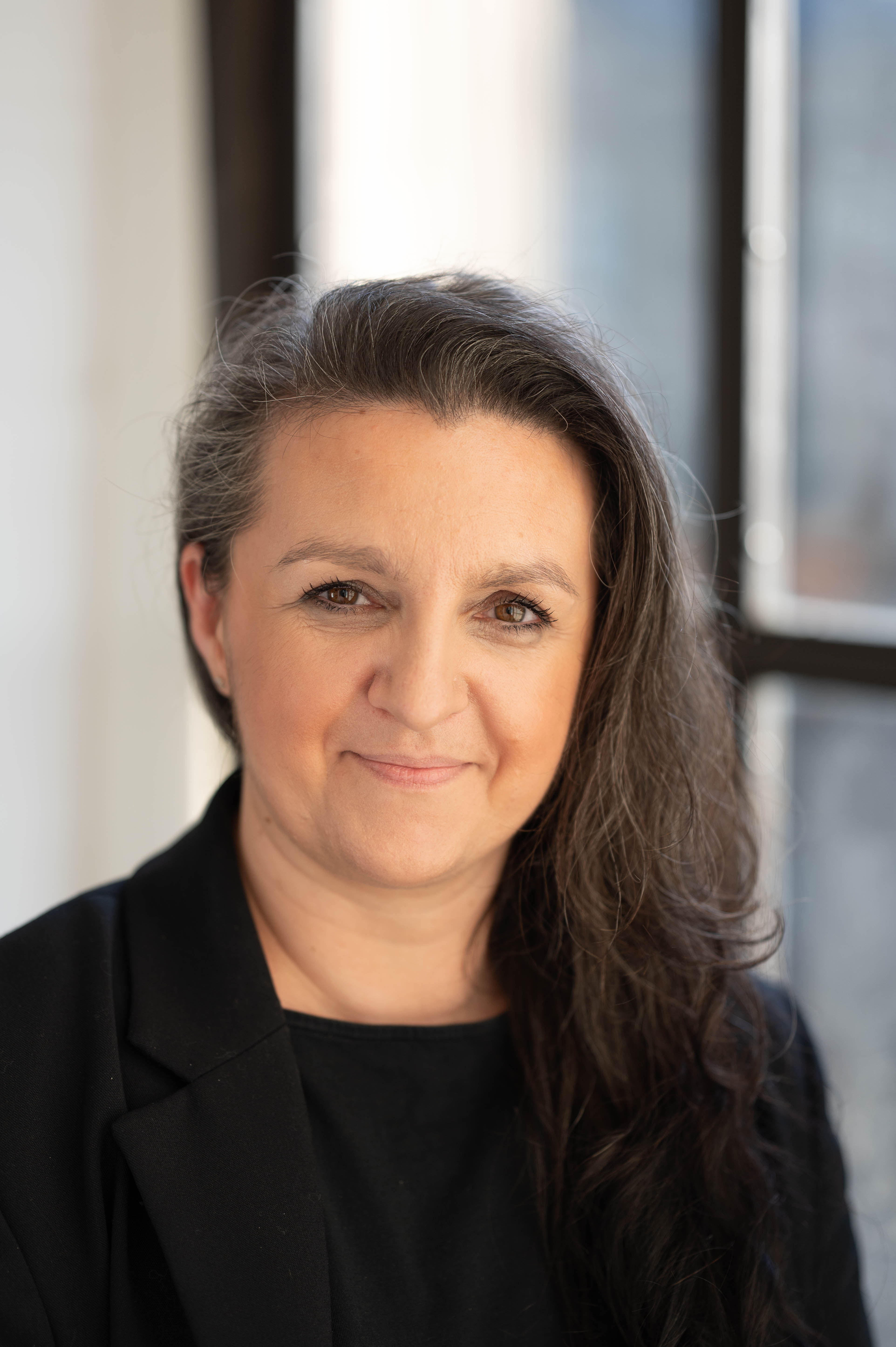 A lady posing for a headshot and smiling at the camera