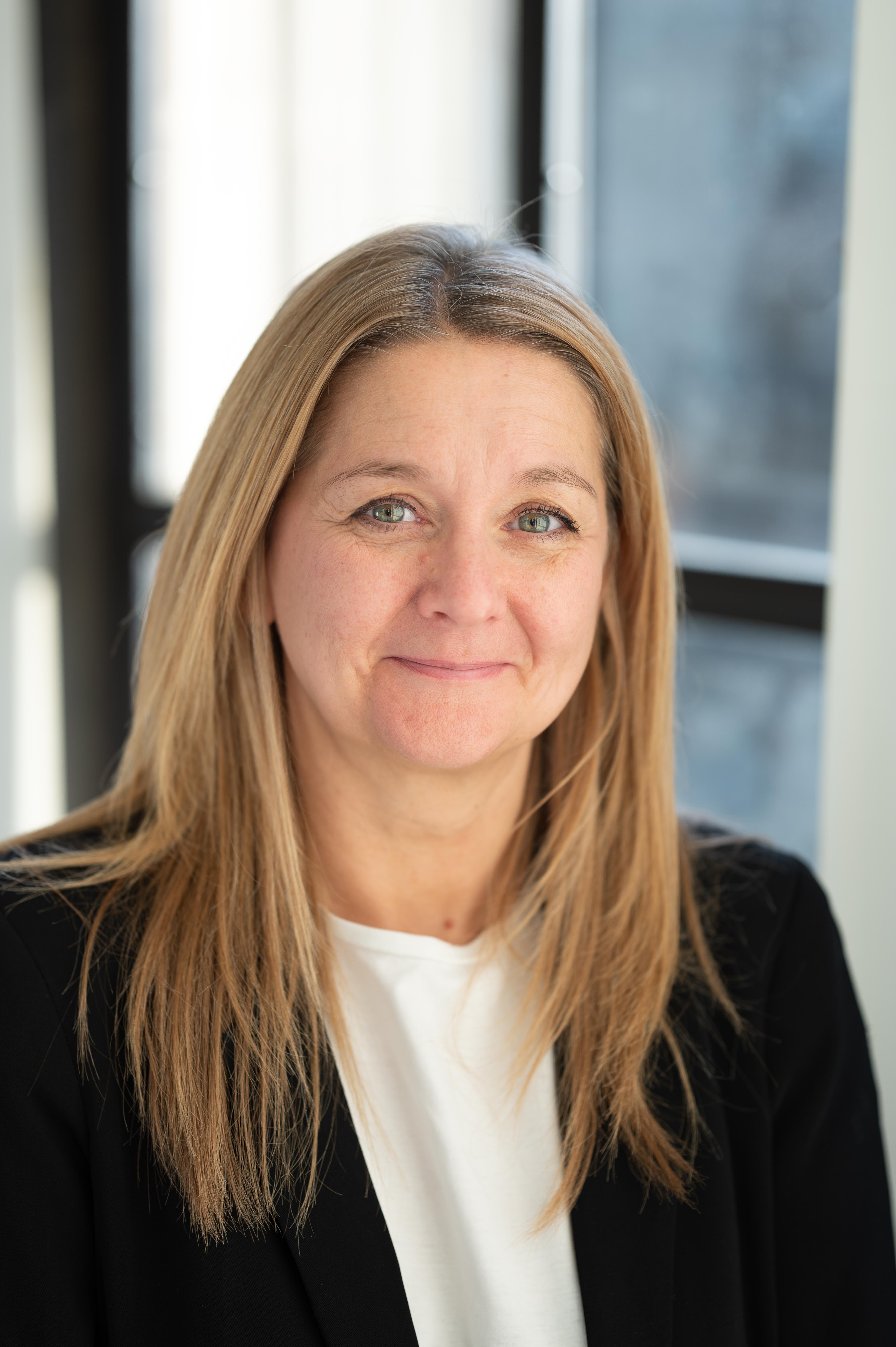 A headshot of Oldham Council's Business Compliance Support Officer, Martine. She is smiling and looking at the camera.