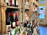 An image of wines and beers on wooden crate style shelves