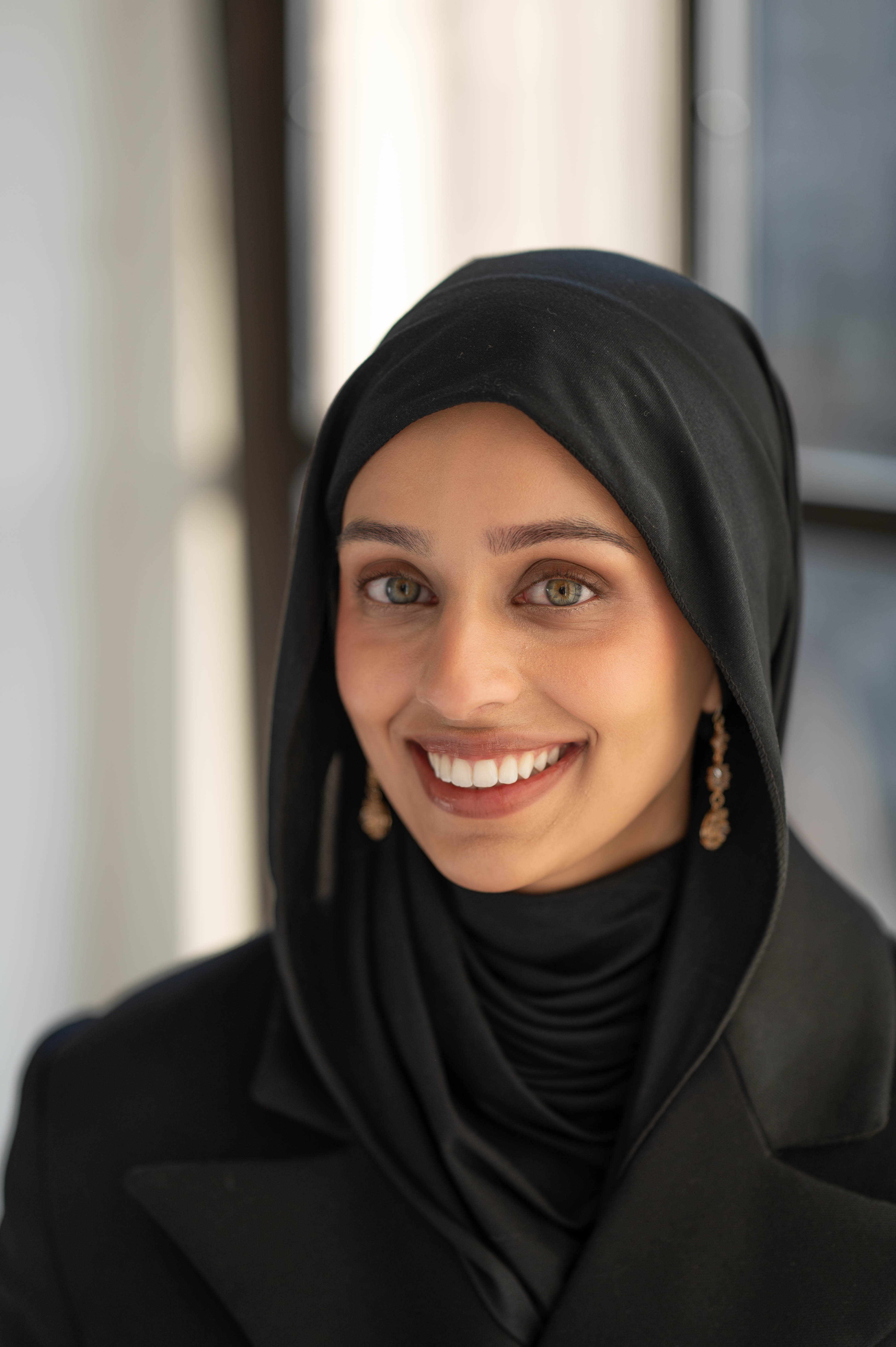 A young lady posing for a headshot and smiling at the camera