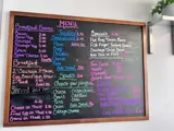 A cafe menu on a wall. Written in coloured chalk