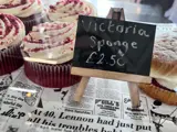 Cakes in a cake counter with a small chalkboard showing the price
