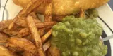 A plate with fish, chips and mushy peas