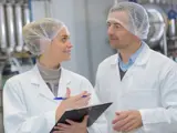 A female and male environmental health officers wearing hairnets 