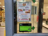 The window of a cafe containing a menu and a "5" food hygiene rating sticker